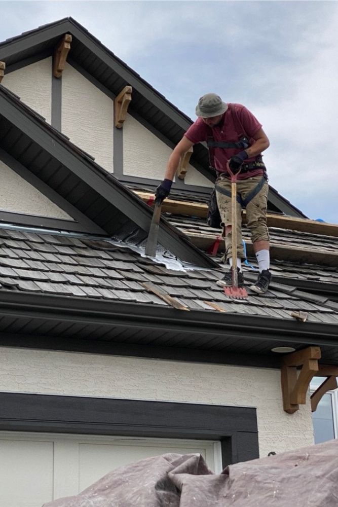A man using a hammer to work on a roof, showcasing our roofing services in Reno, NV.