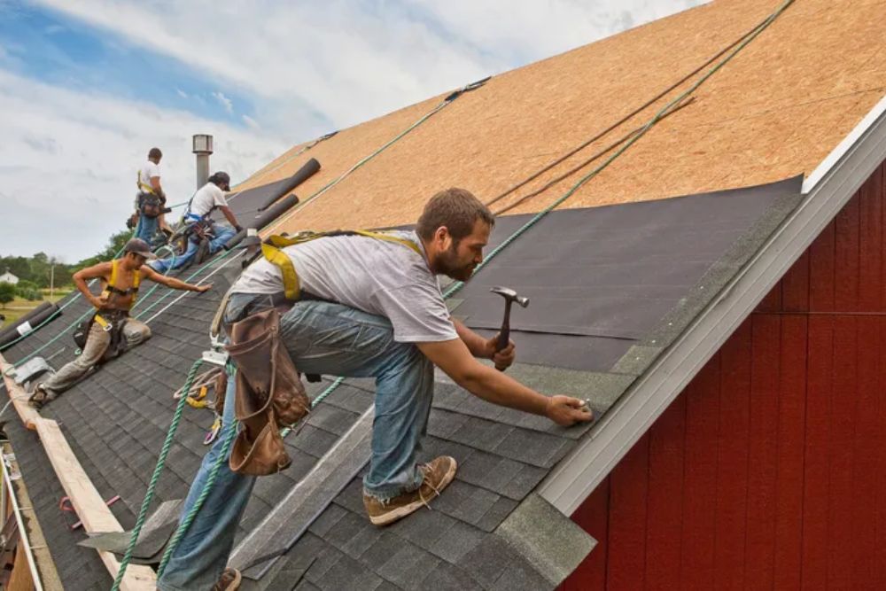A man diligently hammering on a roof, representing our roofing maintenance expertise in Reno, NV.
